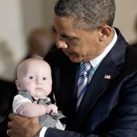 Name game: President Barack Obama holds a baby at the White House Father’s Day luncheon in Washington on June 14. Baby names by red and blue, not pink and blue
