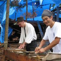 Cutting edge: The multinational carpenters sharpen their tools. Rustic building fest spans two continents