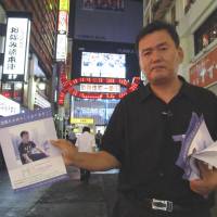 Campaign goes on: Sung-won Kang hands out flyers in Kabuki-cho while visiting Tokyo in 2011 to find information about the death of his son, Scott Kang, who was found comatose in a stairwell the entertainment district on Aug. 24, 2010. He died six days later. Police stonewalling over death of U.S. teen in Shinjuku prolongs family's ordeal