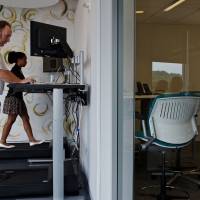 Taking health in their stride: Michelle Schneider and Dave Dunn use treadmill desks at Evolent, a health-care startup in Arlington, Virginia. Researchers are trying to determine whether the equipment allows people to burn off glucose that accumulates in the bloodstream. Standing up for a longer life span
