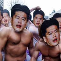 Inspired: Supporters of brash Internet entrepreneur Takafumi Horie, the former president and CEO of Livedoor Co. Ltd., pose in masks representing Horie in front of the Tokyo District Court in March 2007. Japan's maverick entrepreneurs offer Abe lessons in growth