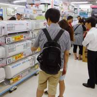 Sales soar: Customers check out air conditioners at Bic Camera’s flagship electronics store in Ikebukuro, Tokyo, on Friday. Heat wave buoys sales of cooling goods