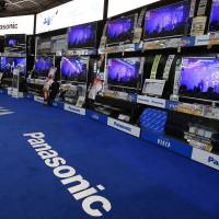 Devil in the detail: A man looks over Panasonic flat-screen television sets at an electronics store in Tokyo on Wednesday. Panasonic profit up 8.4-fold due to shakeup
