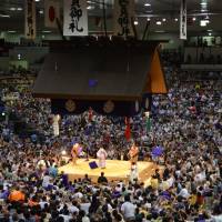 Zabuton cushions go airborne after ozeki Kisenosato downs yokozuna Hakuho at the Nagoya Basho. Hakuho moves past Asashoryu to third on the all-time greatest list