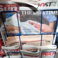 The prince and the paper: A selection of British national newspapers showing the royal baby on a news stand in London on July 24. Royal media machine protects newborn prince, for the moment