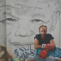 Fighting tribute: Shanghai-based Belgian artist Phil Akashi poses Thursday in front his portrait of South African peace icon and former boxer Nelson Mandela, which he forged by pounding the wall 27,000 times with a boxing glove bearing the kanji for “freedom.” Mandela mural punched onto Chinese wall in tribute to freedom icon
