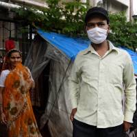 Questionable care: A cancer patient stands outside a temporary shelter located on the pavement outside Tata Memorial Hospital in Mumbai at the beginning of August. Some of the city’s streets act as an unofficial ward for patients attending one of India’s top cancer treatment centers. Indian cancer patients sleeping rough