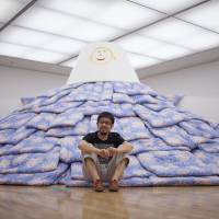 Work and play: Tsuyoshi Ozawa with a mountain of futons, which he created for kids in Fukushima. Art fiction that keeps our thinking adept