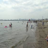 Wade in: Visitors enjoy Kasai Rinkai Park's beach, the first natural Tokyo beach opened to swimming in 51 years. Tokyo beach reopens after five-decade effort