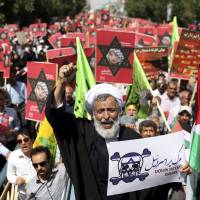 Leading the crowd: An Iranian cleric holds an anti-Israeli placard as he chants slogans while attending an annual pro-Palestinian rally marking Al-Quds (Jerusalem) Day in Tehran on Friday. Iran's Rouhani faces pressure over economy