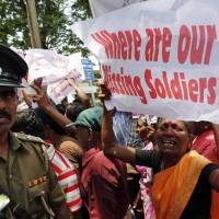 Seeking answers: An ethnic Tamil woman supporting the Dead and Missing Person's Parents Front cries as she holds up a placard during a protest in Colombo on Friday. Sri Lanka more autocratic: U.N.