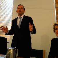 New man: Australian Prime Minister-elect Tony Abbott (center) speaks to newly elected members along with the deputy leader of the Liberal Party, Julie Bishop (right), and National Party leader Warren Truss at Parliament House in Canberra on Friday. Abbott's new style eases pace of Australia politics
