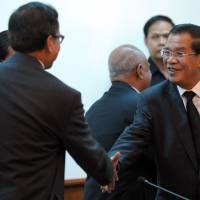 Cooler heads: Cambodian Prime Minister Hun Sen (right) shakes hands with Sam Rainsy, leader of the opposition Cambodia National Rescue Party, during a meeting at the National Assembly in Phnom Penh on Monday. Cambodia rivals meet after protest bloodshed