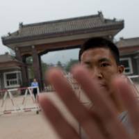 Follow the rules: A plainclothes police officer attempts to stop photographs from being taken outside Qincheng Prison, on the outskirts of Beijing, earlier this month. The prison is where fallen highflier Bo Xilai is expected to be incarcerated. Hotel-style prison likely awaits Bo