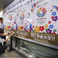 Welcome to the world: Subway station attendants in Tokyo put up posters that commemorate the decision to award the 2020 Olympics and Paralympics to the capital last week. Travel shows warp true globalization
