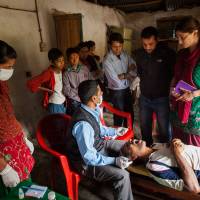 Tooth fairy: Laura Spero (standing, right), speaks with dental technician Raju Adhikari (seated), at a weekly dental clinic in Lahachowk, Nepal. Spero, a native of Greenwich Forest, Maryland, learned that Nepalese villagers expected their teeth to fall out with age. For 10 years, she has been doing something to change their assumptions. John B. Saving the smiles of Nepal with good dental care