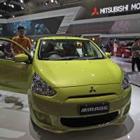 Kicking the tires: An attendee checks out at a Mitsubishi Motors Corp. Mirage displayed at the Indonesia International Motor Show in Jakarta on Sept. 20, 2012. MMC on verge of ¥200 billion public share offering