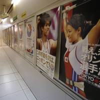 Cash in!: Official posters promoting Tokyo's bid for the 2020 Olympics hang on the wall of a subway concourse in Tokyo on Wednesday. At stake in bid — ¥3 trillion