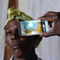 Eye opening: Using a special lens, a technician scans the eye of a woman with the “Eye-Phone” smartphone application as she takes part in an ophthalmological study in the village of Kianjokoma, Kenya, last week. New invention a sight for sore eyes