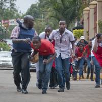 Civilians flee from Westgate Mall after police exchange gunfire with militants in Nairobi on Saturday. Militants kill 59, take hostages in Kenya mall