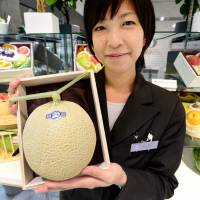 Bearing fruit: Miyuki Kaida, who works at the Sun Fruits luxury fruit store in Tokyo Midtown, shows a high-quality melon Sept. 17. Masters of luxury fruit grow money on trees