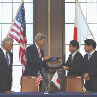 Swap shop: Signed documents are exchanged Thursday in Tokyo by (from left) U.S. Secretary of Defense Chuck Hagel, U.S. Secretary of State John Kerry, Foreign Minister Fumio Kishida and Defense Minister Itsunori Onodera. Defense, diplomacy chiefs sidestep SOFA
