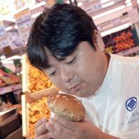 Undaunted: Harumoto Hagi, a chef from Fukushima Prefecture, sniffs mushrooms Monday during a visit to Paris. Fukushima chef raises residents' morale with trip to France