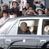 Public display: Emperor Akihito waves to the public as his car arrives at Kumamoto airport Monday afternoon. Emperor felt public affinity in '92 China trip