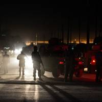 Truly bazaar: Afghan police guard the site of an attack by a Taliban suicide bomber on foreign troops in Kabul on Friday. As the U.S. troop withdrawal from the country and sell-off of equipment accelerates, the Taliban have become part of the world’s biggest garage sale U.S. drawdown in Afghanistan sees world's biggest garage sale
