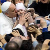 Charmer: Pope Francis kisses a baby in St. Peter’s Square prior to his weekly general audience at the Vatican in April. Pope's plain talking stirs fresh debate