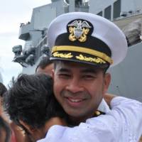 Reunion: U.S. Navy Cmdr. Michael Misiewicz, then-skipper of the guided-missile destroyer USS Mustin, is greeted by a member of his family after the vessel arrived in Sihanoukville, Cambodia, in December 2010. U.S. Navy rocked by bribery scandal