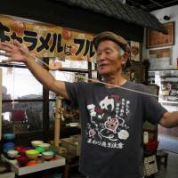 Old master: Yoshihito Fujita demonstrates a spinning top technique at his home-turned-museum in Nagoya. Top aficionado plans contest to test the best spinners