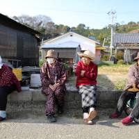 On the sidelines: Elderly women sit by the side of a road on Gogo Island in Matsuyama, Ehime Prefecture, in March. Tax-free gifts unlocking retiree savings