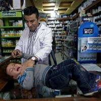 Home safe: Lebanese pharmacist Wissam Khatib, who was seized as a hostage by a gang but then released, checks a child at his store in Zahleh, east Lebanon. The country has seen a dramatic spike in kidnappings in an unusual knock-on effect from the civil war in neighboring Syria, as gangs whose usual of cross-border smuggling business has suffered amid the conflict turn to snatching well-off local businessmen for ransom Syrian war leads to spate of kidnappings in Lebanon