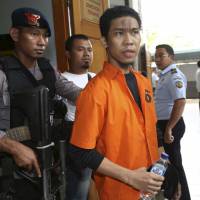 Plot foiled: Suspected militant Separiano is escorted by uniformed and plainclothes police upon arrival for his trial in South Jakarta District Court on Wednesday. He stands accused of conspiring to attack the Myanmar Embassy in Jakarta Indonesian plotted on Facebook to attack Myanmar Embassy, court told
