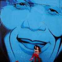 Face of a nation: Two girls are seen beneath a wall mural of former South African President Nelson Mandela in Cape Town on Dec. 7. Mandela saw massive change in Africa
