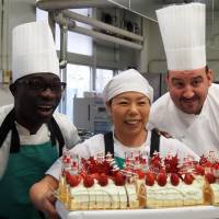 Freshly baked: Chef Christoph Paucod (second from right) and members of his French culinary team Caravan Bon Appetit pose with a cake they prepared at an elementary school in Koriyama, Fukushima Prefecture, on Dec. 9. The team members visit the 2011 quake and tsunami disaster sites in Tohoku to serve French cuisine every month. Nuke refugee kids get gourmet meal
