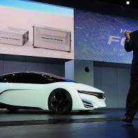 Independent thinking: Tetsuo Iwamura, executive vice president of Honda Motor Co. and president of American Honda Motor Co., speaks on stage next to the automaker’s FCEV concept vehicle at the LA Auto Show in Los Angeles on Nov. 20. Honda says profit will determine pay