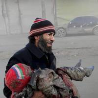 Combatants?: A man cries while holding the body of a child killed following some of the most sustained airstrikes by regime forces in Aleppo, Syria, on Sunday. In Syria, jihadists train 'children of al-Qaida'