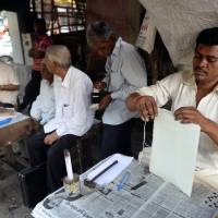 A stitch in nine: A letter writer sews up a parcel at his roadside stall opposite the General Post Office in Mumbai on Dec. 6. India's last generation of letter writers signs off
