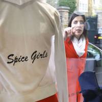 Spice at a fraction of the price: A woman looks through the window at items donated by the Beckhams at a Red Cross charity shop in London last month. Britain's charity shops go after the label-conscious but risk alienating the bargain-seekers