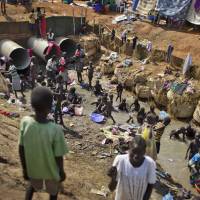 The state we’re in: Displaced people bathe and wash clothes Friday in a stream inside a U.N. compound in Juba that has become home to thousands of people displaced by fighting. In its eagerness to set up a separate state in Sudan’s south at all costs, the international community failed to take into account the area’s deep ethnic divisions. How the West fell for the 'big lie' about South Sudan