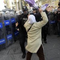 Explosive situation: A woman confronts a Turkish riot policeman during a protest in Istanbul on Thursday. Turkey's leaders meet in attempt to defuse row over judicial curbs