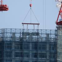 Making more: Workers labor on a residential building under construction in Tokyo on Nov. 22. Demand for industrial materials is showing clear signs of recovery, with steel and cement production in 2013 hitting their highest levels in five years. Industrial materials demand rebounding