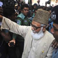 Sentenced to die: Matiur Rahman Nizami, head of Bangladesh’s main Islamist opposition party, enters a prison van outside a court in Chittagong on Thursday after he was sentenced to death on charges of smuggling weapons to a rebel group in neighboring India. Bangladesh court sentences top Islamist to death in epic arms smuggling case