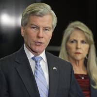 Once a governor: Former Virginia Gov. Bob McDonnell makes a statement as his wife, Maureen, listens during a news conference in Richmond on Tuesday, after they were indicted on corruption charges. Former Virginia Gov. McDonnell, wife indicted for corruption