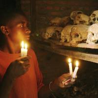 The unknown victims: Rwandan genocide survivor Apollan Odetta lights candles at a mass grave in Nyamata on April 6, 2004. France on trial in Rwanda genocide case