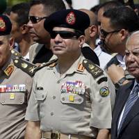 Egypt’s Defense Minister Gen. Abdel-Fattah el-Sissi (center), Prime Minister Hazem el-Beblawi (right), and army Chief of Staff Lt. Gen. Sedki Sobhi (left) attend the funeral of Giza Police Gen. Nabil Farrag in Cairo on Sept. 20, 2013. Egypt’s interim prime minister Hazem el-Beblawi announced Monday the resignation of his Cabinet, a surprise move that could be designed in part to pave the way for the nation’s military chief to leave his defense minister’s post to run for president. Egypt's military-backed government resigns