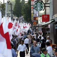 Right in public: Nationalist demonstrators march near the Yasukuni Shrine in Tokyo on Aug. 15, 2013. Nationalist ideas on the Web, known as Netto-uyo (internet ultra-rightist) screeds, are now reaching more of the ordinary Japanese public, including women that Shukan Gendai magazine call “Netto-uyo housewives.” Japan's future may be stunted by its past
