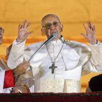 Pope Francis waves to believers from the central balcony of St. Peter's Basilica at the Vatican on March 13, 2013, the day of his election. Francis factor blows away Vatican cobwebs